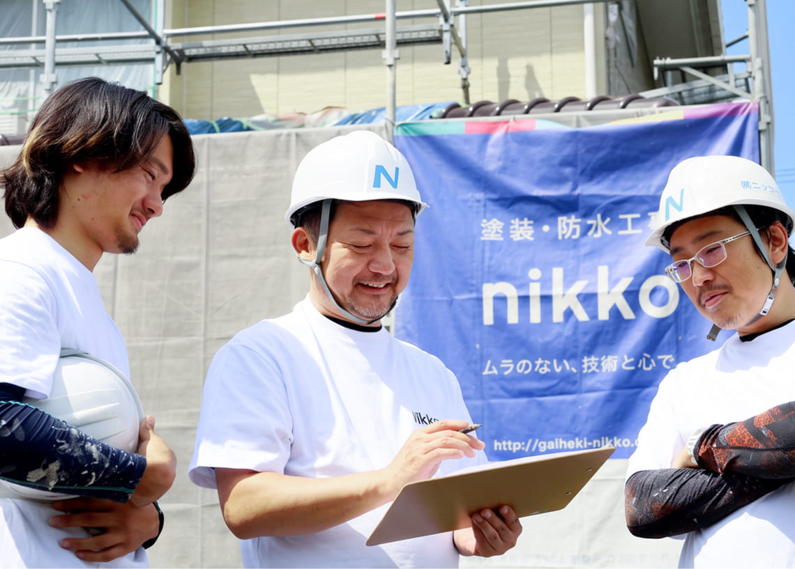 外壁をローラーで塗装する職人